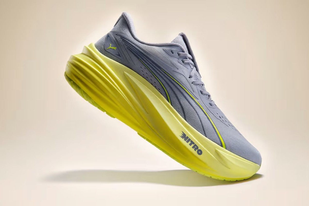Seitenansicht des Puma Magmax Nitro Laufschuhs in Grau mit markanter neongelber NITRO-Sohle.