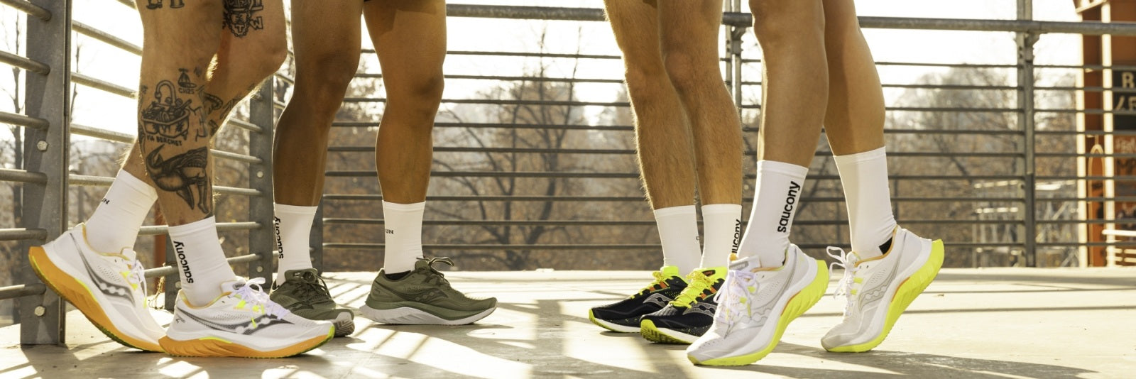 vier Beine mit Laufschuhen und Socken von Saucony